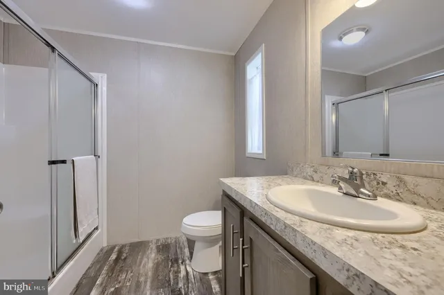 a bathroom with a granite countertop sink a toilet and a mirror