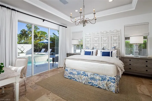 a spacious bedroom with a large bed and a chandelier