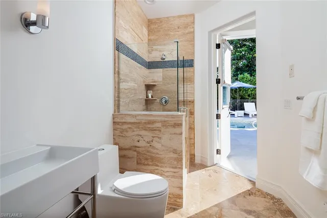 a bathroom with a granite countertop toilet a sink and a mirror