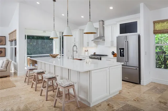 a kitchen with stainless steel appliances kitchen island granite countertop a refrigerator and a stove top oven