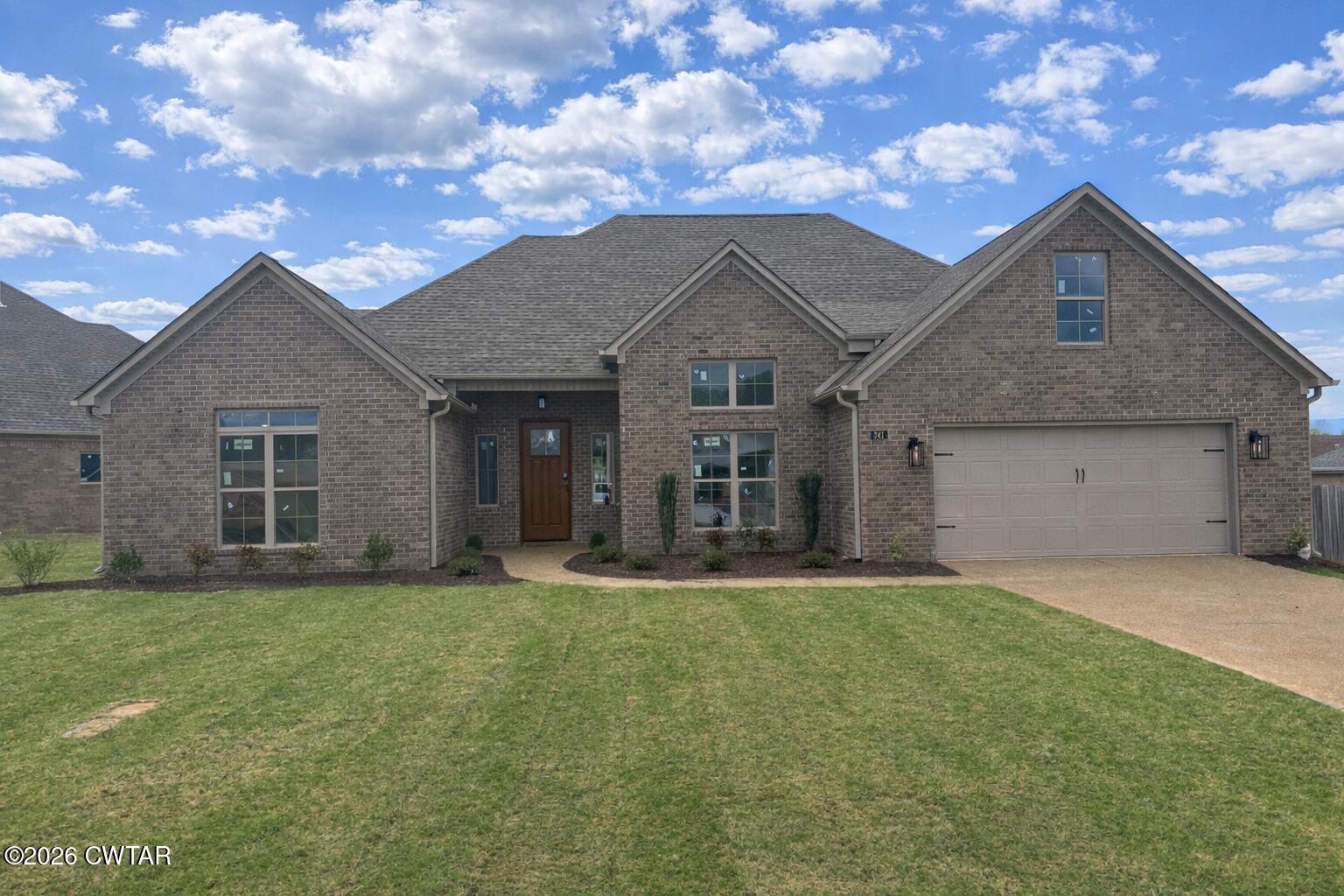 a front view of a house with a yard and garage