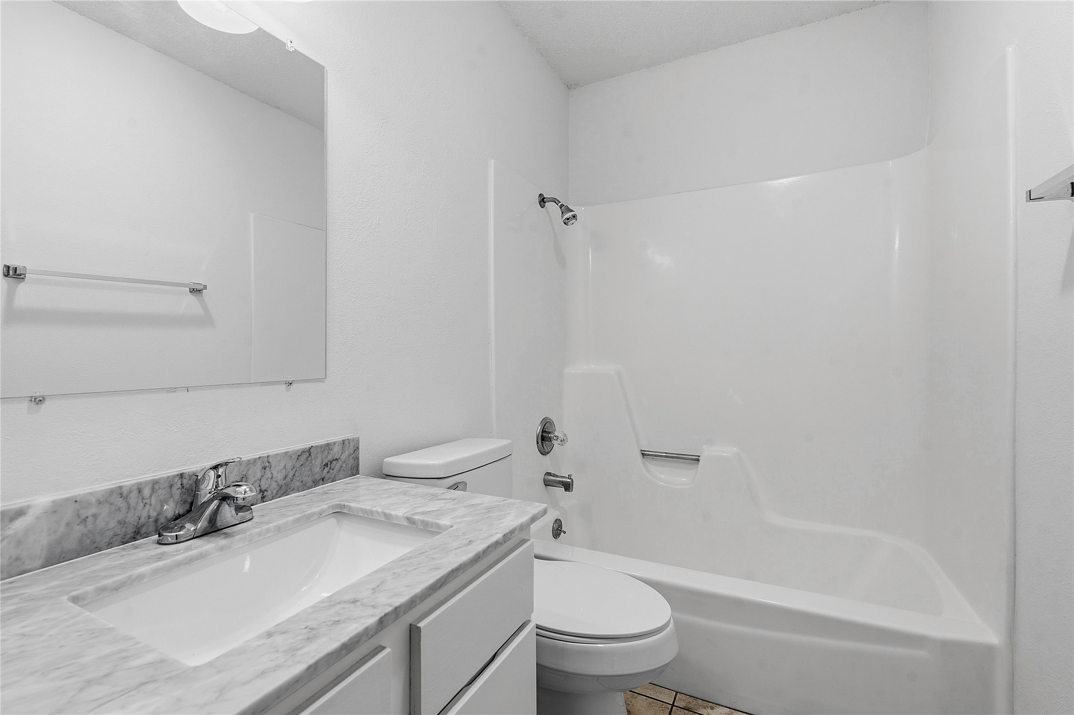 6205 Shadow Bend Austin, TX 78745 - Photo 25 of 31 White fixtures and a gray marble-style vanity offer a clean, functional bathroom space.