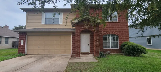 front view of a house with a yard and an trees