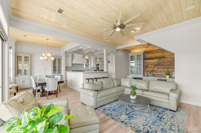 a large white kitchen with a stove a sink a refrigerator and white cabinets