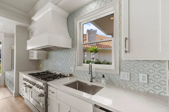 a spacious bedroom with a large bed a chandelier and a window