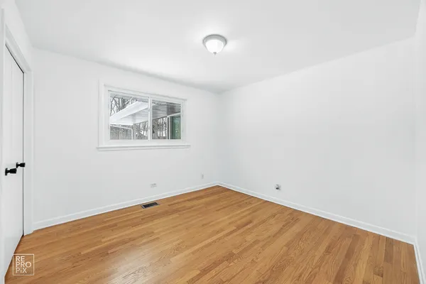 a view of empty room with wooden floor
