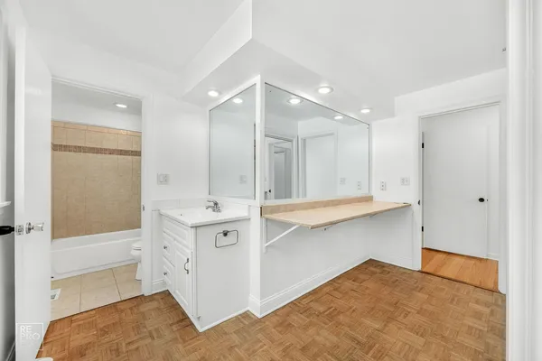 a bathroom with a sink double vanity granite tub shower and a mirror