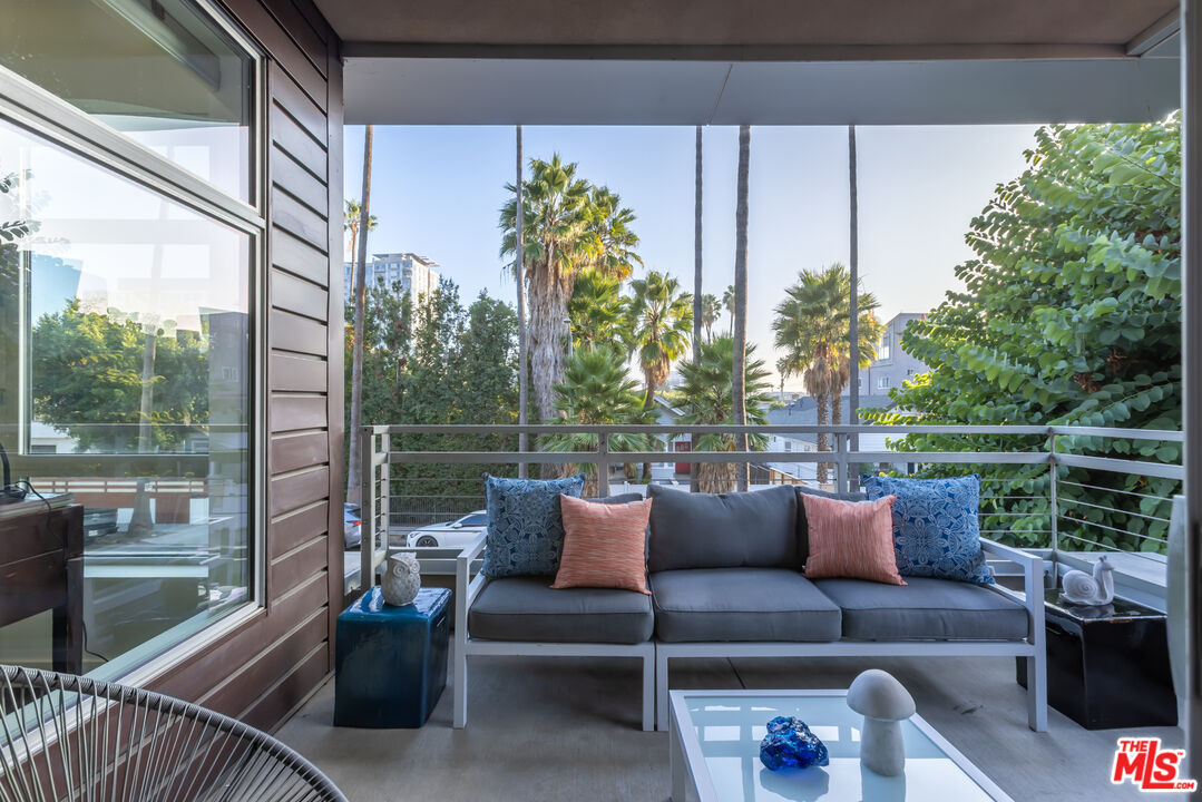 a balcony with furniture and a potted plant