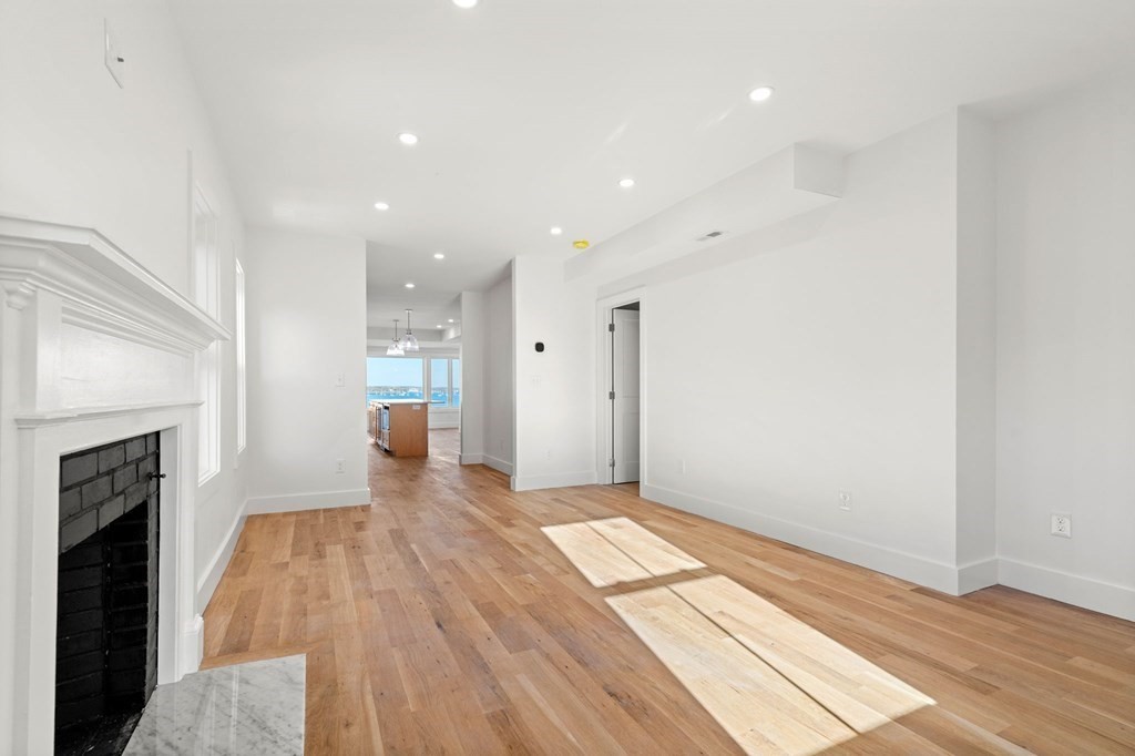 111 Leach Street, Unit 1 Salem, MA 01970 - Photo 12 of 32 a view of an empty room with wooden floor and a fireplace