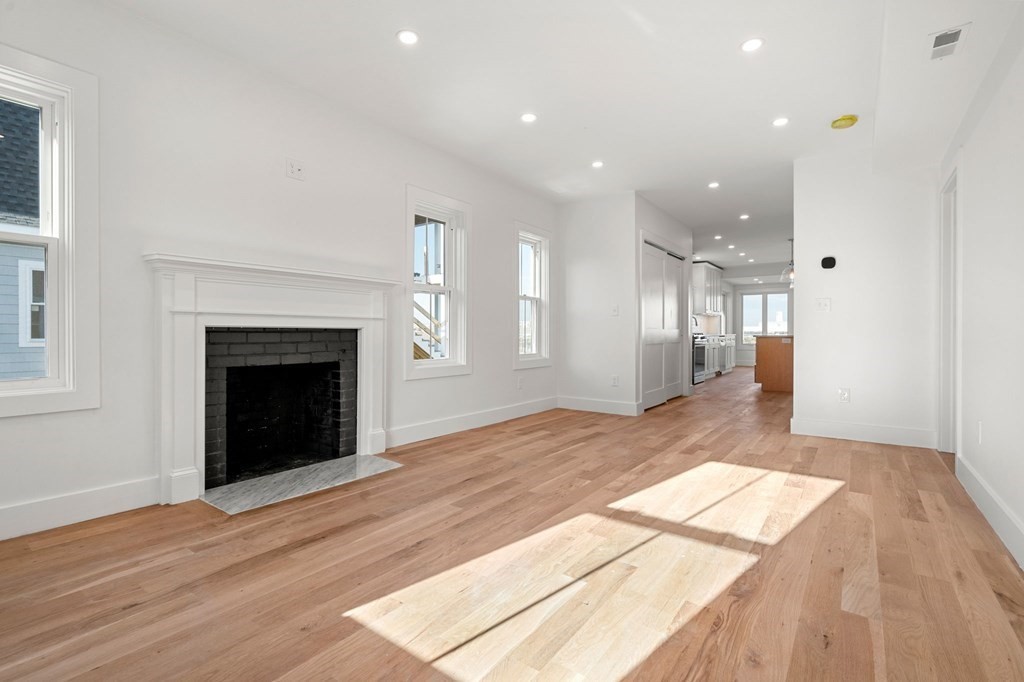 111 Leach Street, Unit 1 Salem, MA 01970 - Photo 14 of 32 a view of a big room with wooden floor and a fireplace