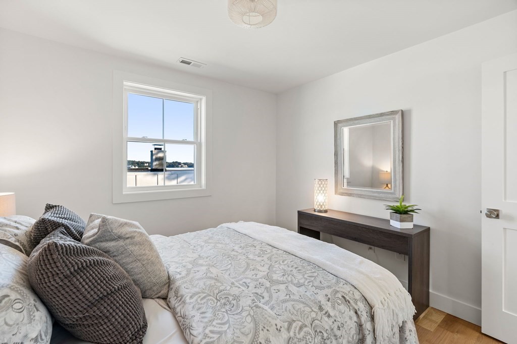 111 Leach Street, Unit 1 Salem, MA 01970 - Photo 21 of 32 a bedroom with a bed and wooden floor