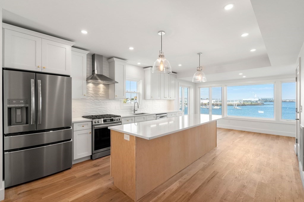 111 Leach Street, Unit 1 Salem, MA 01970 - Photo 3 of 32 a large kitchen with stainless steel appliances kitchen island granite countertop a stove a refrigerator a sink and a oven with wooden floor