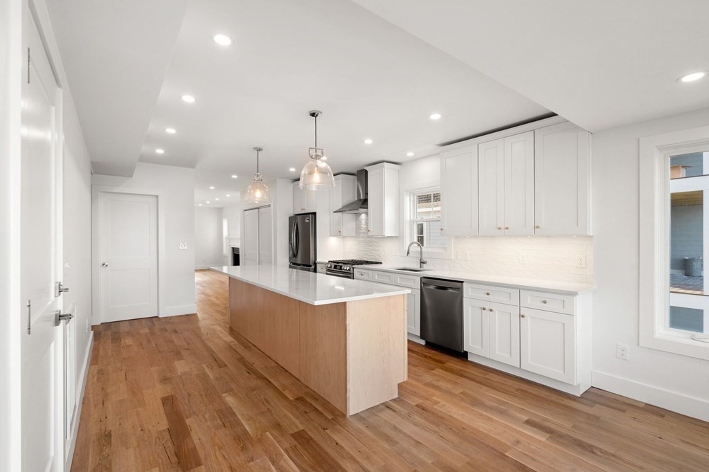 111 Leach Street, Unit 1 Salem, MA 01970 - Photo 7 of 32 a large kitchen with stainless steel appliances kitchen island granite countertop a stove a sink and a refrigerator