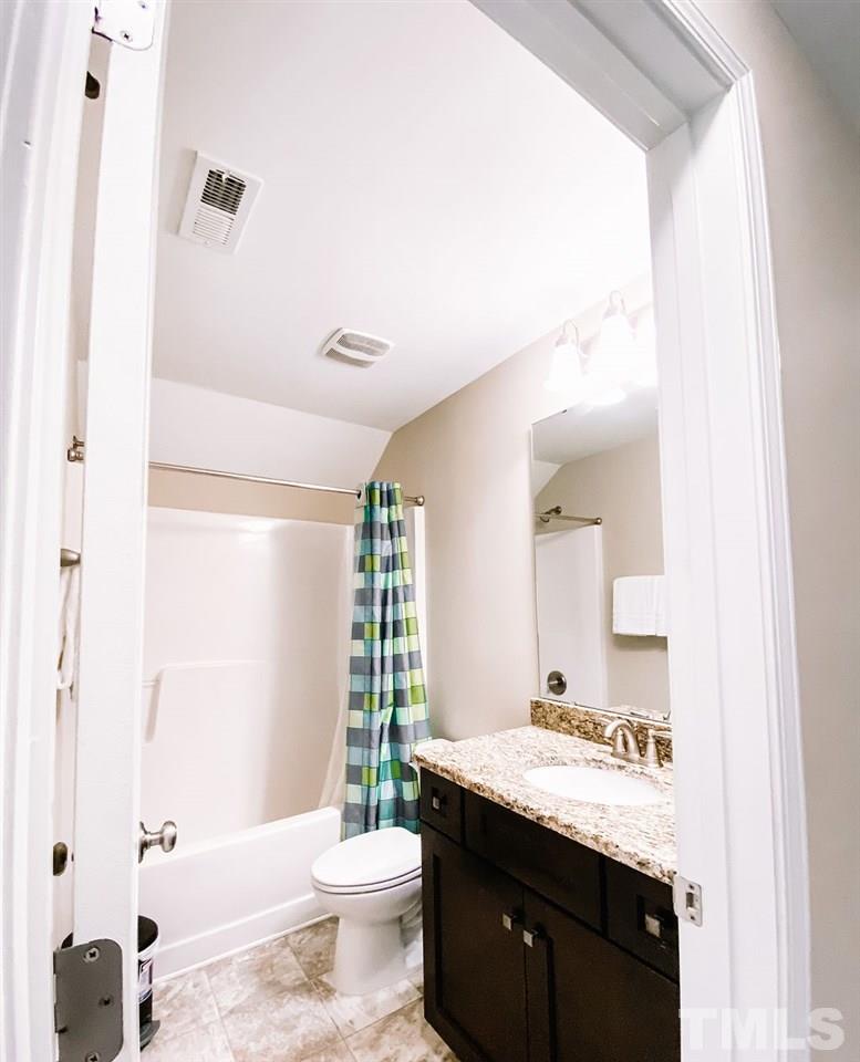 7989 Creech Road Middlesex, NC 27557 - Photo 18 of 20 a bathroom with a granite countertop sink a toilet a mirror and shower