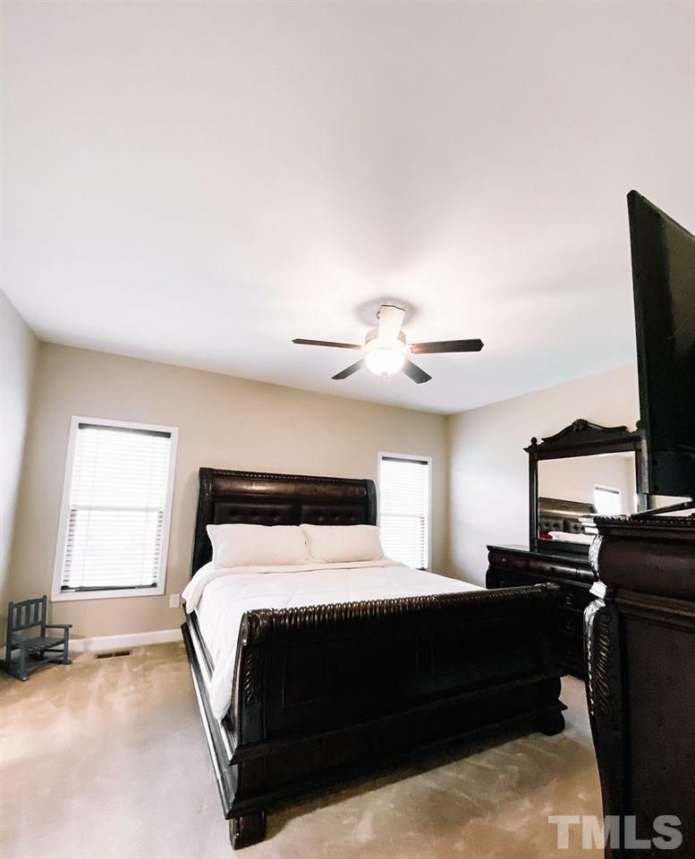 7989 Creech Road Middlesex, NC 27557 - Photo 10 of 20 a bedroom with a bed and a flat screen tv