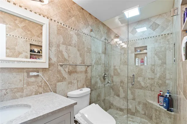 a bathroom with a sink a toilet and shower