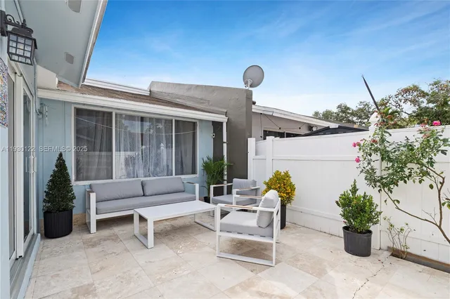 a building outdoor space with patio furniture and potted plants