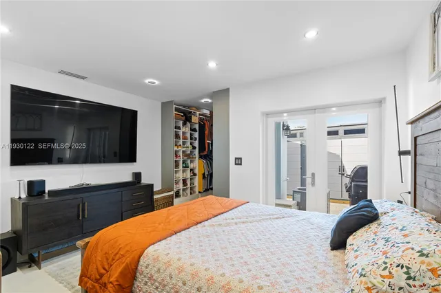 a bedroom with a large bed and a flat screen tv