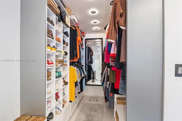 a view of walk in closet with clothes