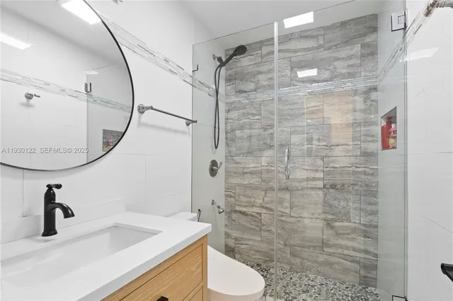 a bathroom with a sink a toilet and shower