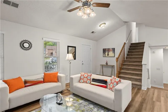 a living room with furniture and a wooden floor