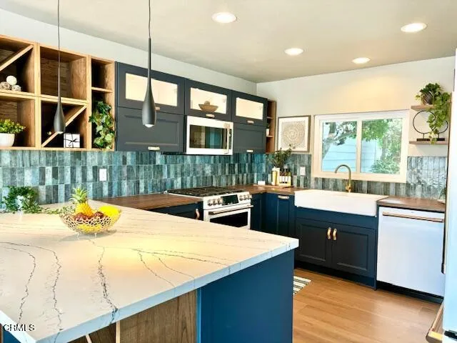 a kitchen with stainless steel appliances granite countertop a sink and a stove