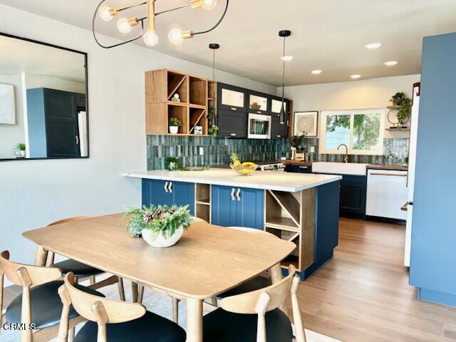 4510 Gateshead Bay Oxnard, CA 93035 - Photo 10 of 34 a kitchen with a stove a counter space a dining table and chairs