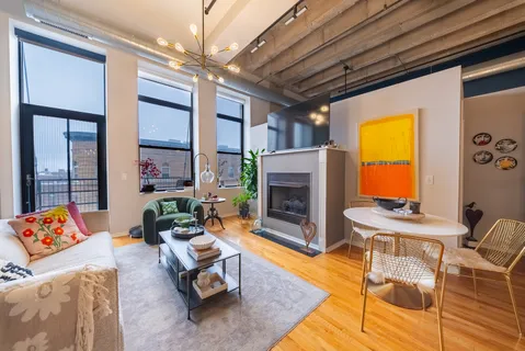 a living room with furniture a fireplace and a chandelier