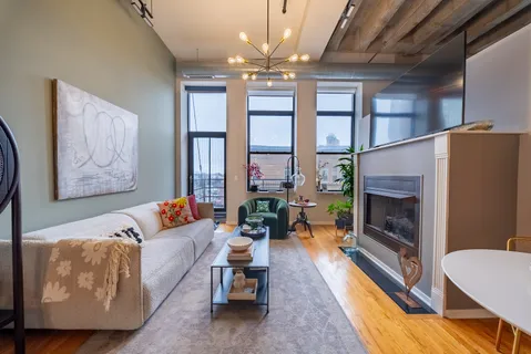 a living room with furniture fireplace and large windows