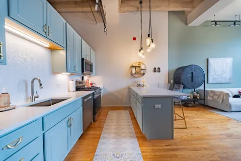 a large kitchen with kitchen island a counter space a sink a window and stainless steel appliances