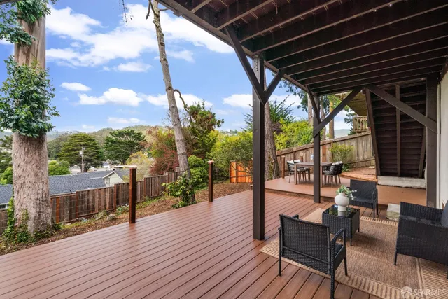 a view of a white house with a large tree