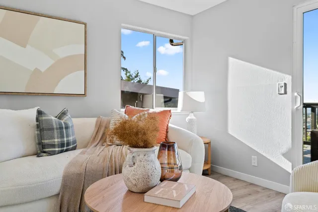 a living room with furniture and a large window with wooden floor