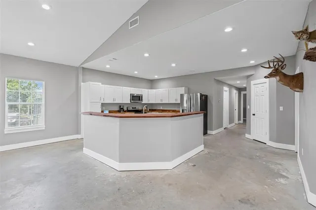 a view of kitchen with kitchen island white cabinets and refrigerator