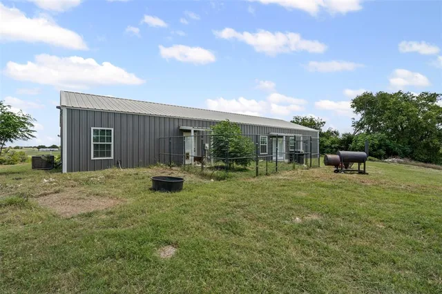 a backyard of a house with table and chairs