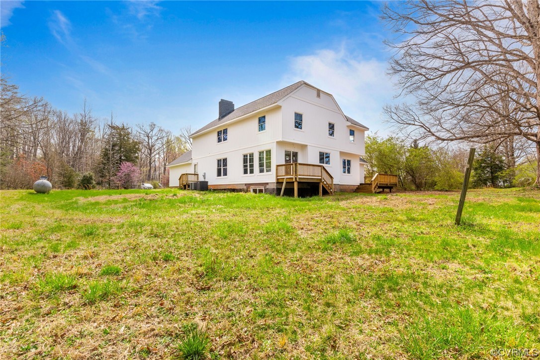 5660 Cartersville Road Powhatan, VA 23139 - Photo 9 of 15 a view of a white house with a big yard and large trees