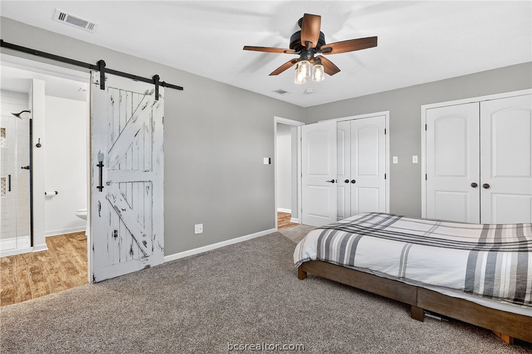 10054 Arnold Lane Bryan, TX 77845 - Photo 16 of 32 a bedroom with a large bed and a chandelier