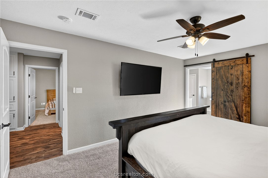 10054 Arnold Lane Bryan, TX 77845 - Photo 19 of 32 a bedroom with a bed and a flat screen tv