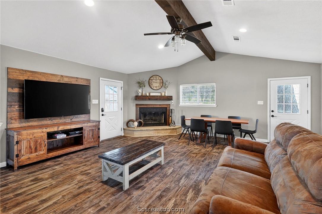 10054 Arnold Lane Bryan, TX 77845 - Photo 25 of 32 a living room with furniture a flat screen tv and a fireplace