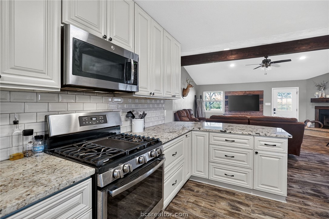 10054 Arnold Lane Bryan, TX 77845 - Photo 6 of 32 a kitchen with stainless steel appliances white cabinets and a stove top oven