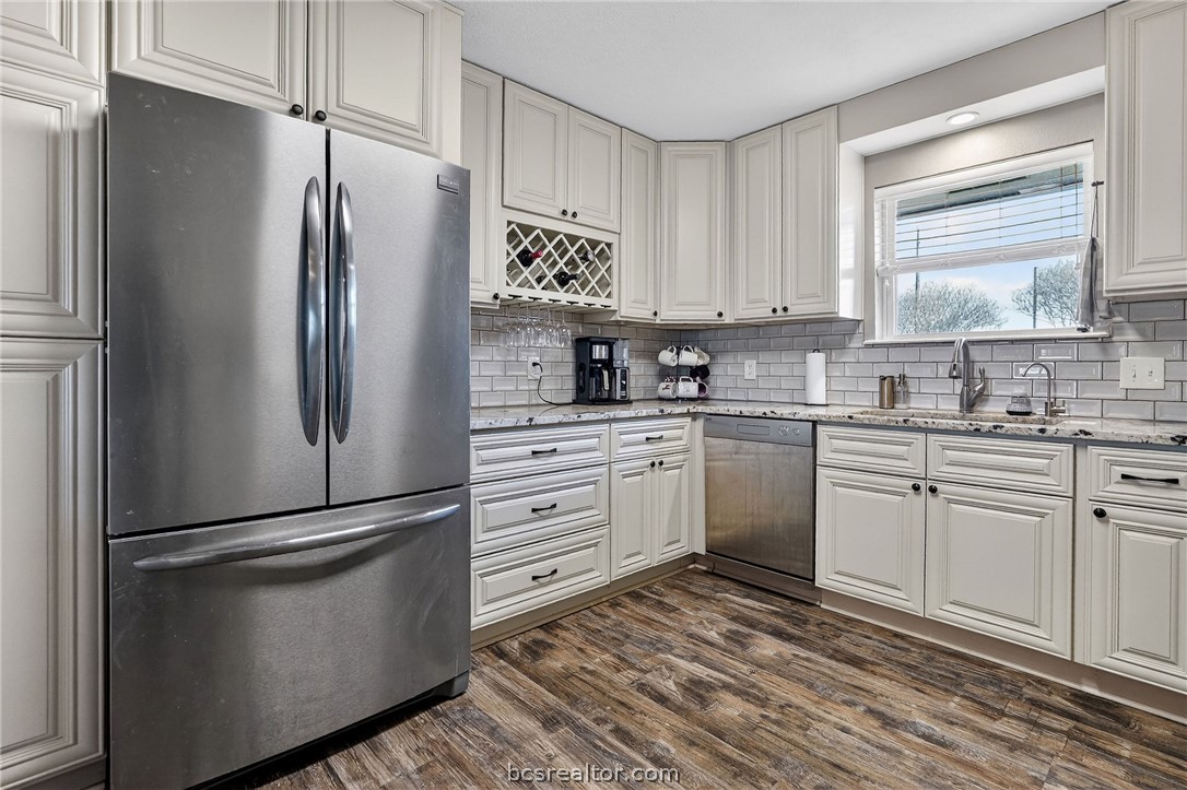 10054 Arnold Lane Bryan, TX 77845 - Photo 8 of 32 a kitchen with white cabinets white stainless steel appliances and sink