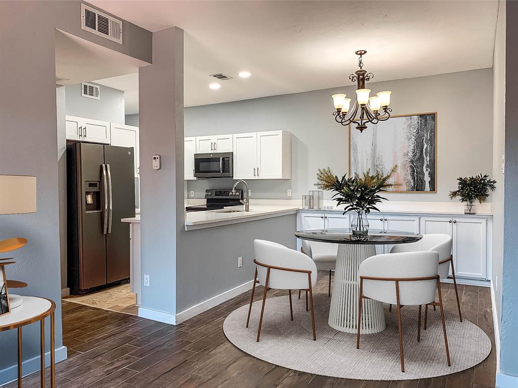 8601 Park Lane, Unit 414 Dallas, TX 75231 - Photo 2 of 23 a view of a dining room with furniture a chandelier and wooden floor