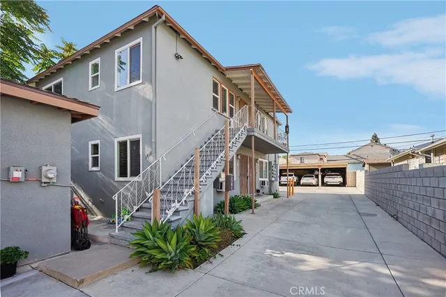 a view of a white house with large windows and a small yard