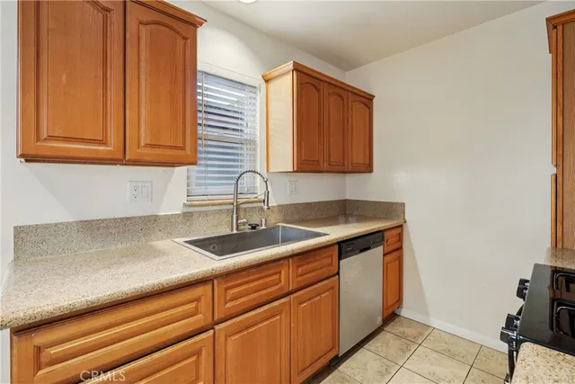 a kitchen with granite countertop a sink and a white cabinets