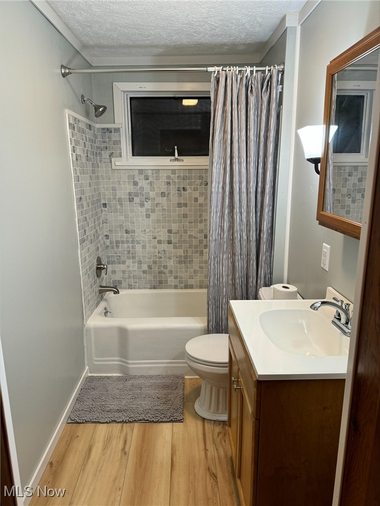 360 Bradys Ridge Road Wellsburg, WV 26070 - Photo 15 of 36 Full bathroom with toilet, vanity, wood-type flooring, a textured ceiling, and shower / bath combination with curtain
