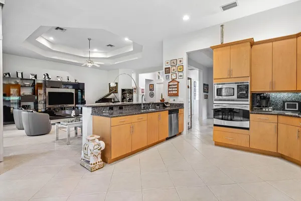 a kitchen with stainless steel appliances kitchen island granite countertop a refrigerator and microwave