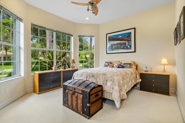 a bed sitting in a spacious bedroom next to a window