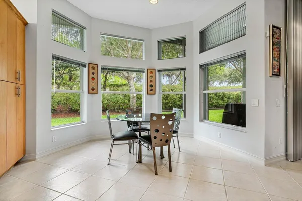 a dining room with furniture and large windows