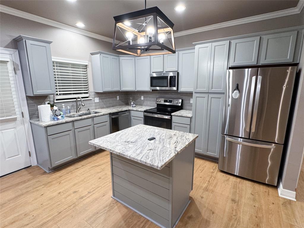901 Lee Street Benton, LA 71006 - Photo 3 of 34 a kitchen with stainless steel appliances granite countertop a refrigerator a sink dishwasher a stove and white countertops with wooden floor