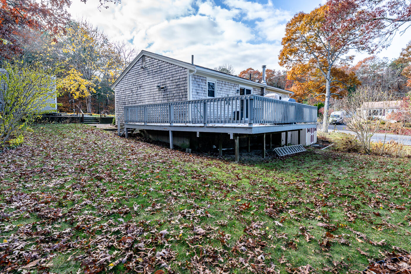 4 Oregon Road Mashpee, MA 02649 - Photo 28 of 31 a backyard of a house with wooden deck and outdoor seating