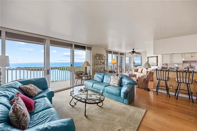 a living room with furniture wooden floor and a floor to ceiling window